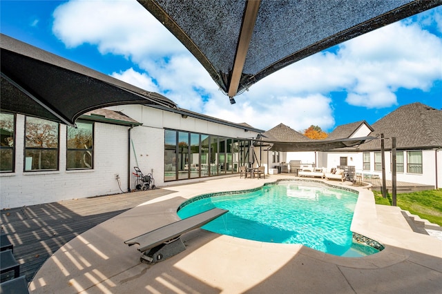 view of swimming pool featuring an outdoor living space, a diving board, and a patio area