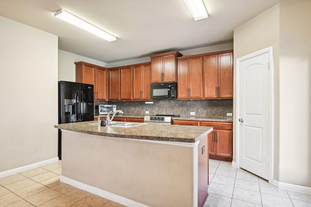 kitchen featuring black appliances, a center island with sink, sink, light tile patterned floors, and tasteful backsplash