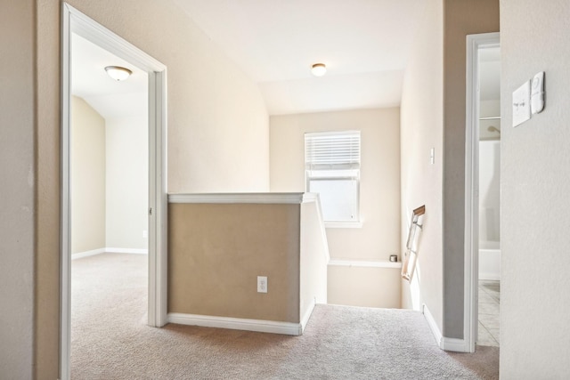 corridor featuring light carpet and vaulted ceiling