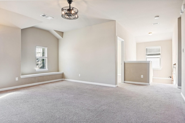 carpeted empty room featuring a healthy amount of sunlight and lofted ceiling