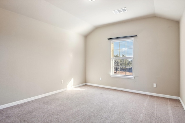 carpeted empty room with lofted ceiling