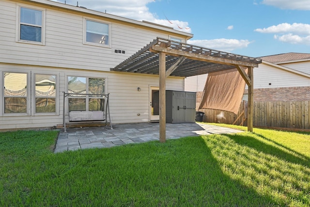 back of house featuring a pergola, a patio area, a lawn, and a storage shed