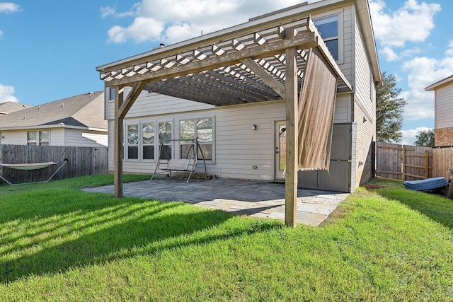 rear view of property featuring a pergola, a patio, and a lawn