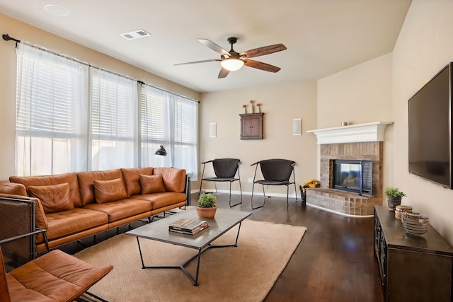2812 Merry View Ln, Fort Worth, TX 76120 - living room featuring visible vents, a brick fireplace, baseboards, ceiling fan, and dark wood-type flooring