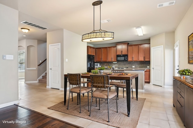 2812 Merry View Ln, Fort Worth, TX 76120 - kitchen featuring hanging light fixtures, visible vents, black appliances, and backsplash