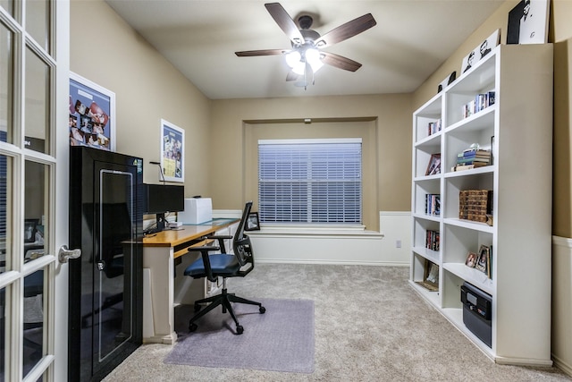 carpeted office space featuring ceiling fan