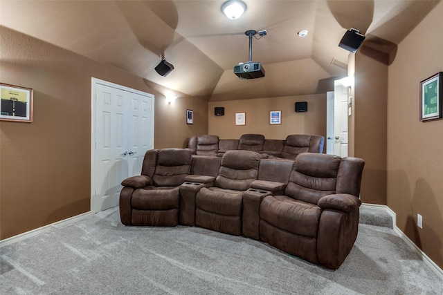 carpeted home theater with vaulted ceiling