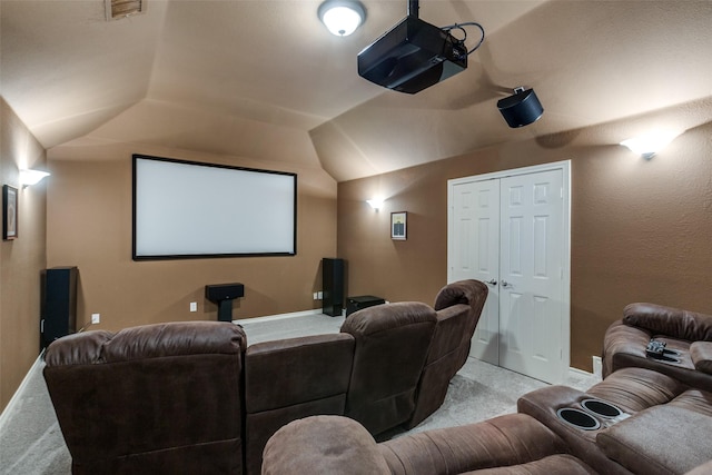 cinema room with light carpet and vaulted ceiling