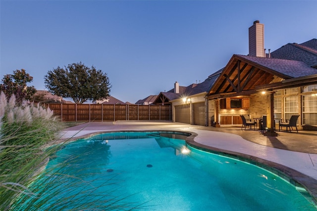 pool at dusk with a patio area