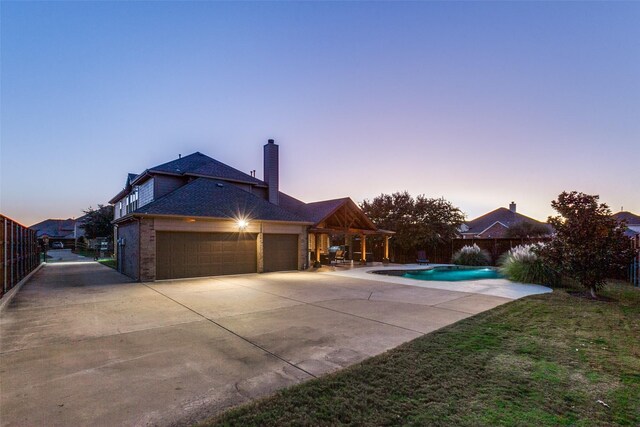 pool at dusk with a patio area