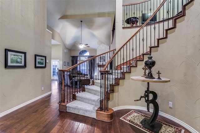 stairway featuring ceiling fan, high vaulted ceiling, and wood-type flooring