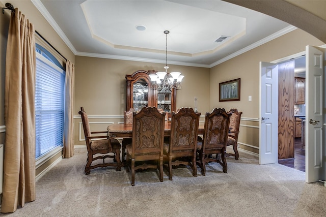 carpeted dining space with a notable chandelier, crown molding, and a tray ceiling