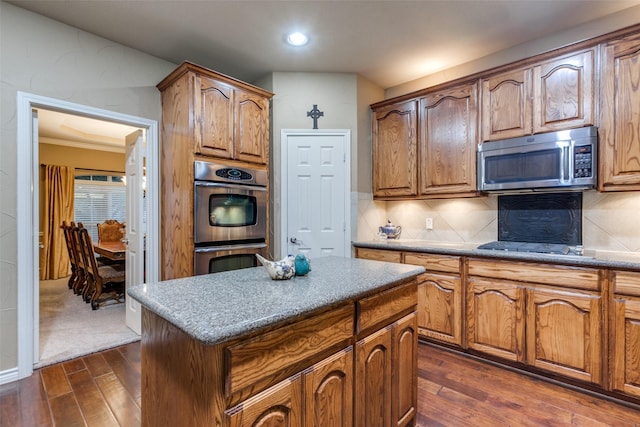 kitchen featuring decorative backsplash, a kitchen island, dark hardwood / wood-style flooring, and appliances with stainless steel finishes