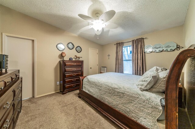 bedroom featuring ceiling fan, light carpet, and a textured ceiling