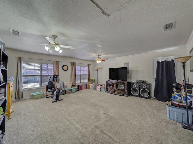 game room featuring ceiling fan, ornamental molding, carpet, and a textured ceiling