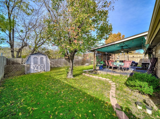 view of yard featuring a patio, ceiling fan, and a storage shed