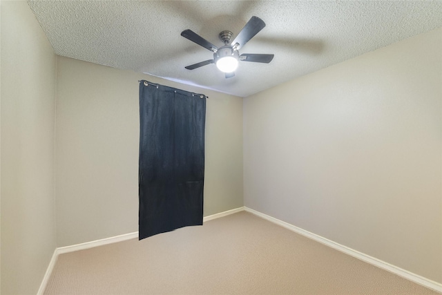 spare room with ceiling fan, a textured ceiling, and carpet flooring