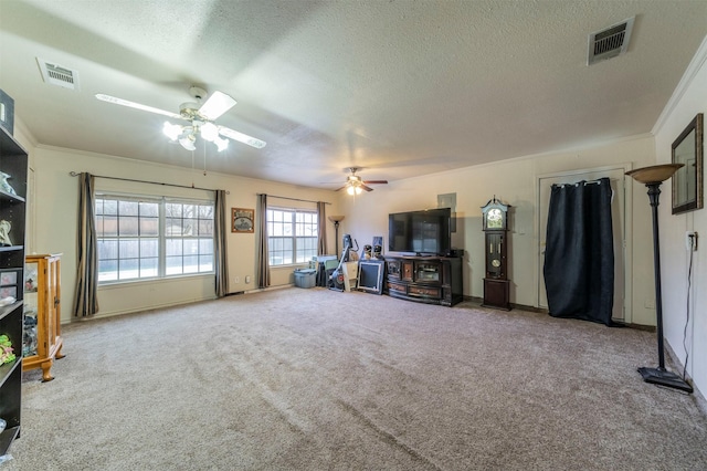 unfurnished living room featuring crown molding, carpet, a textured ceiling, and ceiling fan