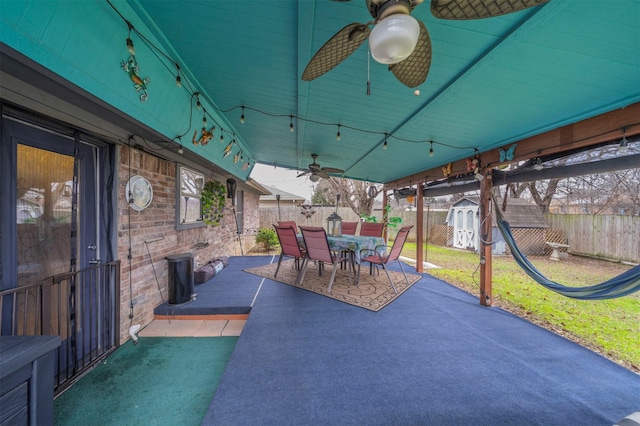 view of patio / terrace with ceiling fan and a storage shed