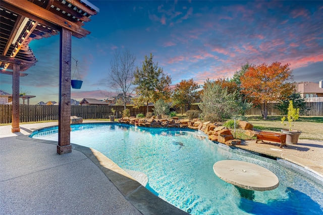 pool at dusk with a patio