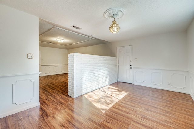 spare room featuring a textured ceiling and hardwood / wood-style flooring