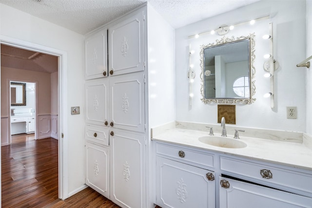 bathroom with vanity, a textured ceiling, and hardwood / wood-style flooring