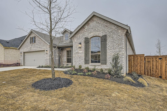 french country style house with a garage and a front yard