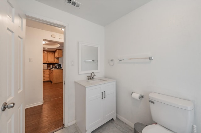 5613 Graham St, Sansom Park, TX 76114 - bathroom featuring baseboards, toilet, vanity, and wood finished floors