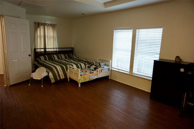 bedroom with dark hardwood / wood-style floors