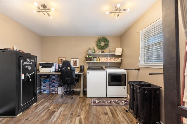 laundry room featuring washer and clothes dryer, hardwood / wood-style floors, and an inviting chandelier