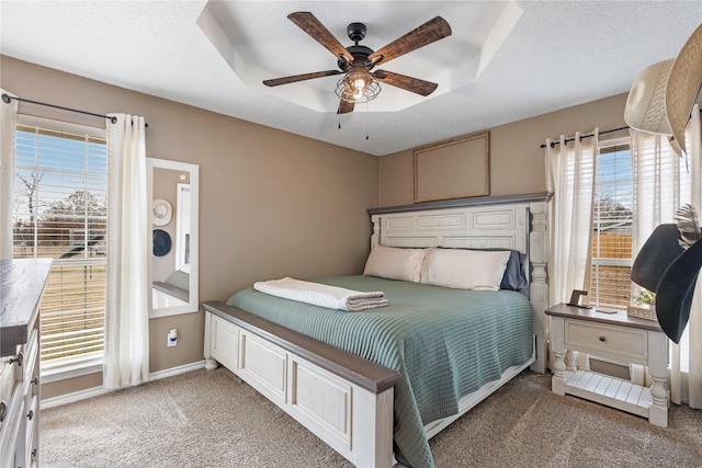 bedroom featuring multiple windows, ceiling fan, carpet, and a textured ceiling