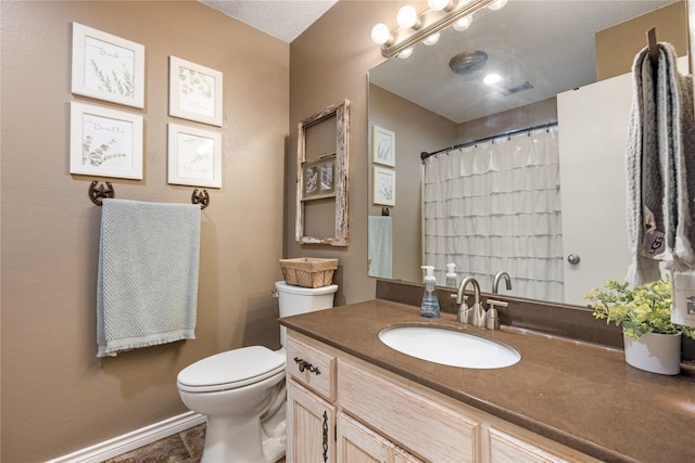 bathroom with vanity, a textured ceiling, and toilet