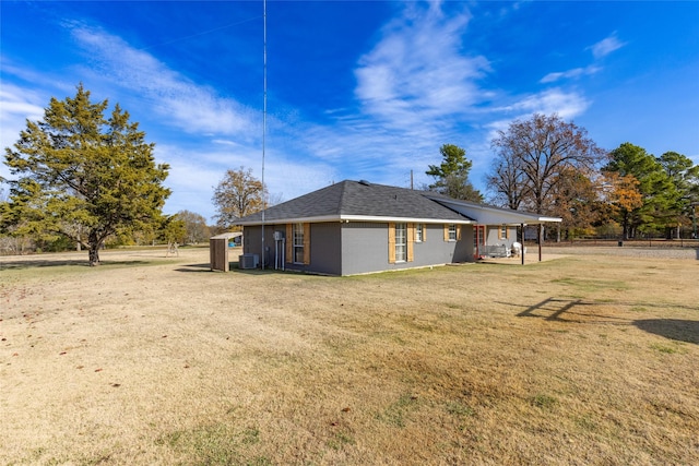 rear view of property featuring a yard and central AC