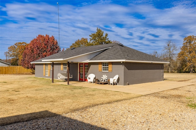 rear view of house with a patio area and a lawn