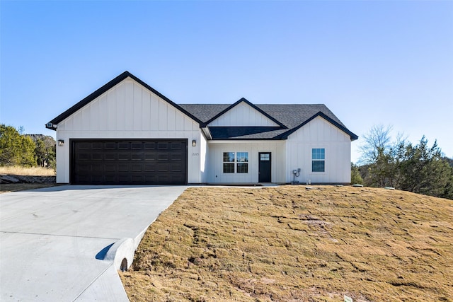 modern inspired farmhouse with a garage and a front lawn