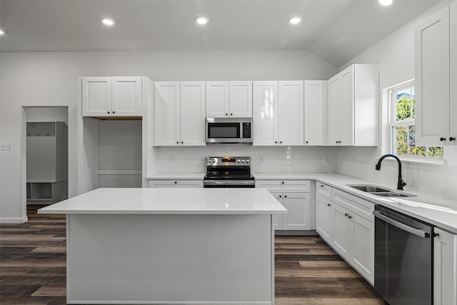 kitchen with stainless steel appliances, a kitchen island, and white cabinetry