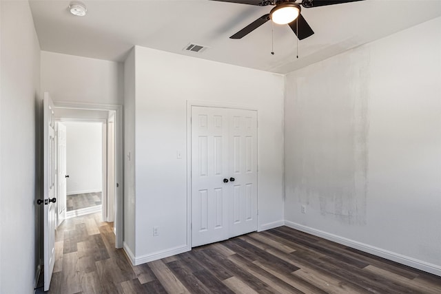 unfurnished bedroom with ceiling fan, a closet, and dark hardwood / wood-style floors