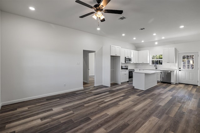 kitchen featuring dark hardwood / wood-style floors, ceiling fan, a kitchen island, white cabinetry, and stainless steel appliances