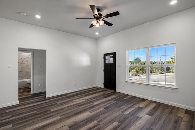 foyer entrance with ceiling fan and dark wood-type flooring