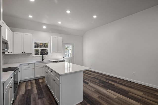 kitchen with black electric range, sink, white cabinets, a center island, and dark hardwood / wood-style floors