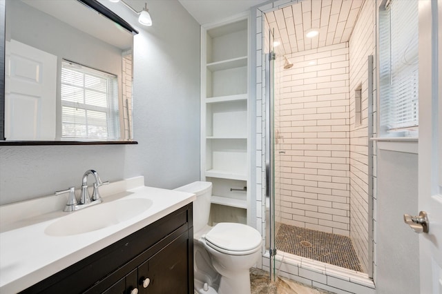 bathroom featuring toilet, an enclosed shower, and vanity