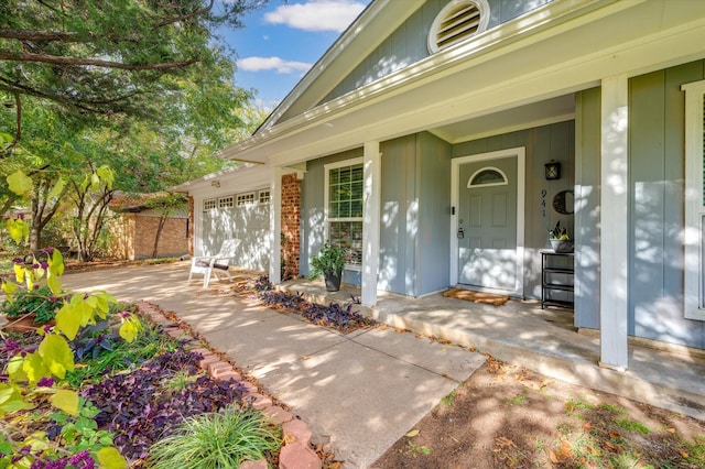 doorway to property featuring covered porch and a garage