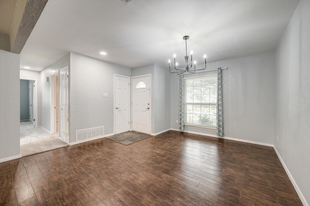 entrance foyer with dark wood-type flooring and an inviting chandelier