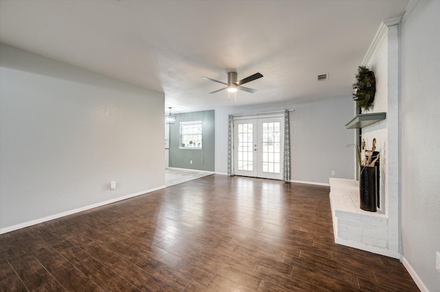 unfurnished living room featuring french doors, ceiling fan with notable chandelier, and dark wood-type flooring