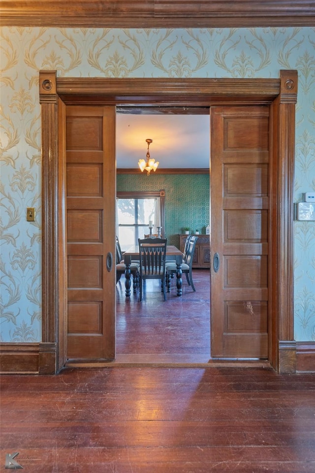 dining area featuring a notable chandelier, ornamental molding, and dark hardwood / wood-style floors