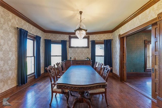 dining area featuring crown molding, dark hardwood / wood-style floors, and a chandelier