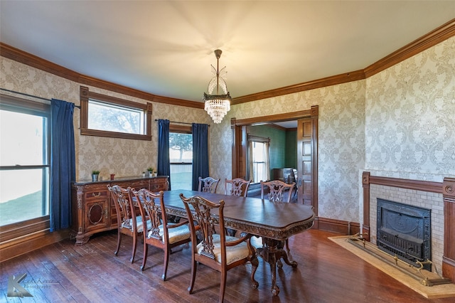 dining space with crown molding, plenty of natural light, dark hardwood / wood-style flooring, and a brick fireplace