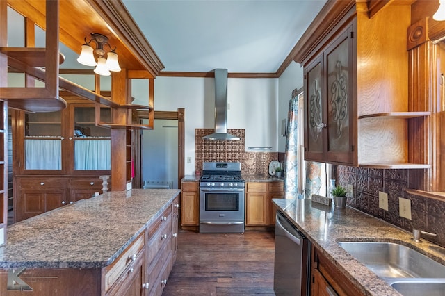 kitchen with appliances with stainless steel finishes, sink, decorative backsplash, crown molding, and wall chimney exhaust hood