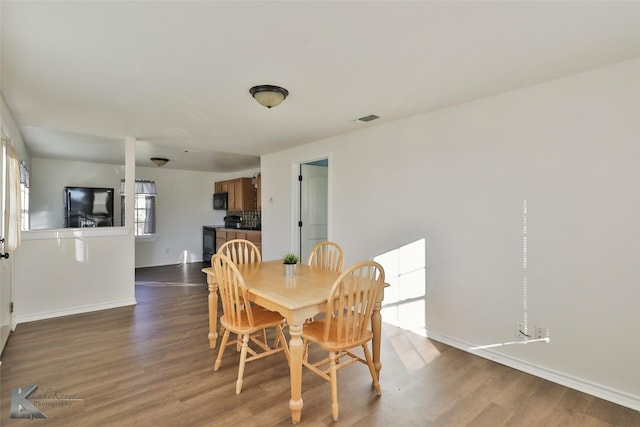 dining area with dark hardwood / wood-style flooring