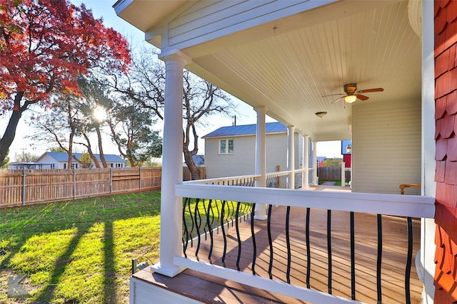 wooden deck with ceiling fan and a lawn